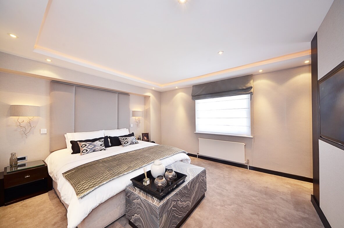 Bedroom with grey roman blind and sheer panels