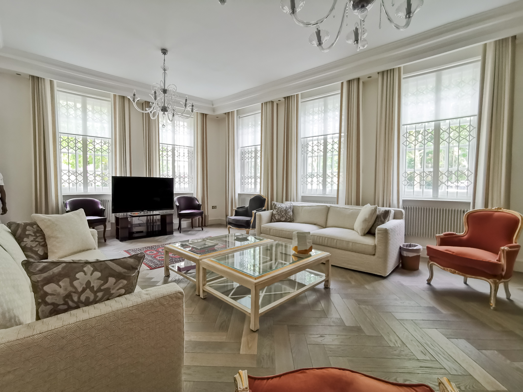 Living room striped sheer curtains and beige upholstered sofas