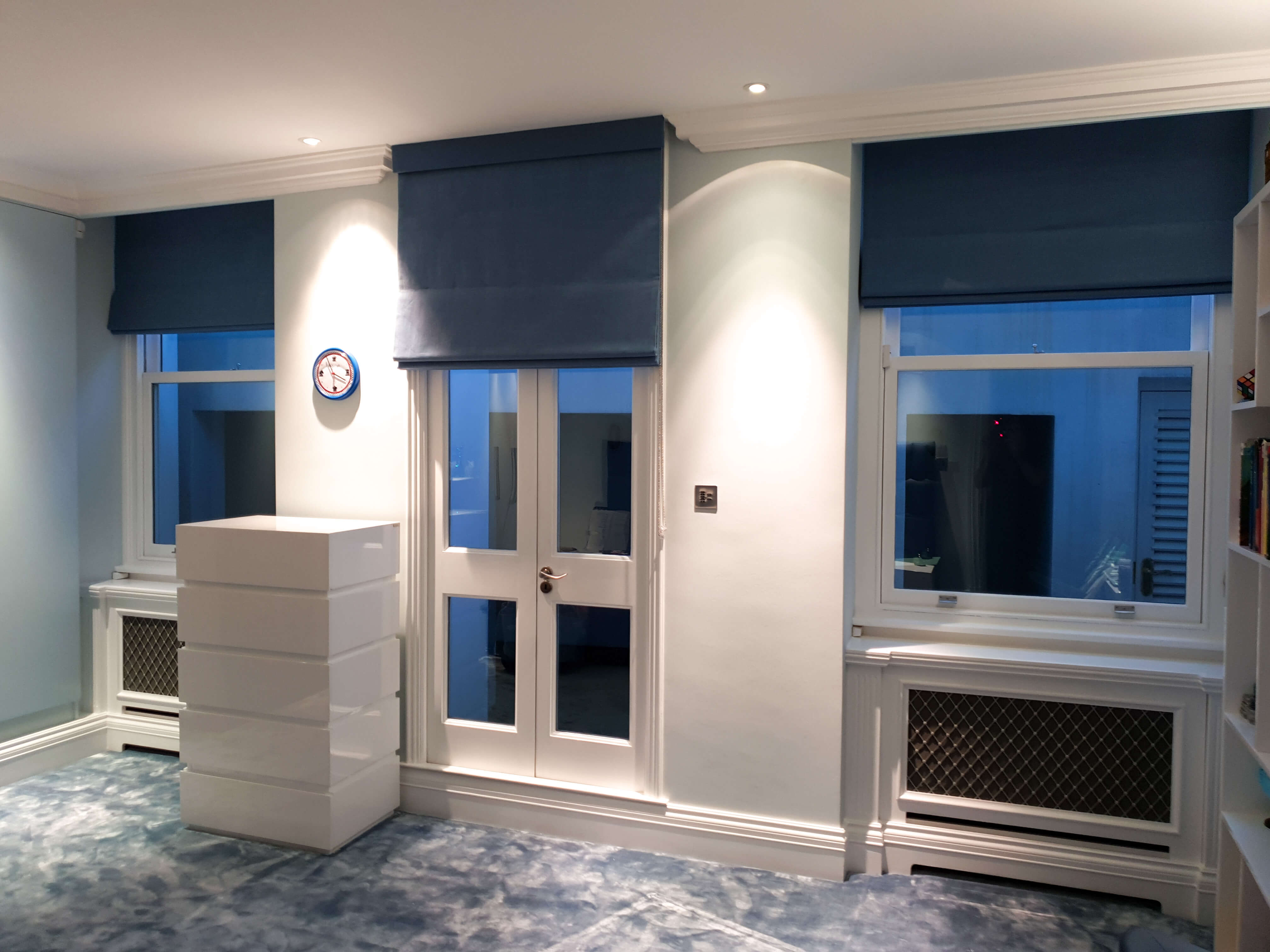 Bedroom with set of blue roman blinds